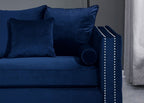 Blue sofa with decorative pillows against a neutral wall.