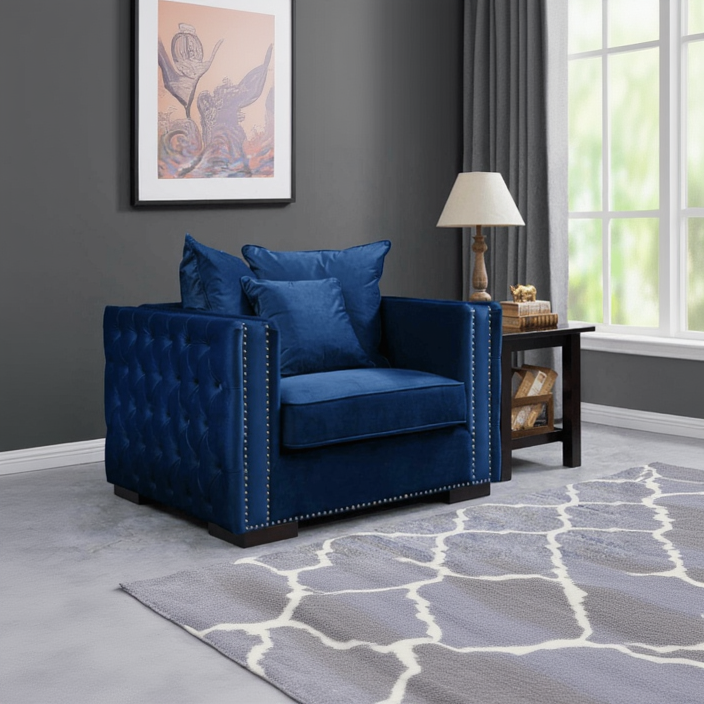 Blue armchair in a living room with a lamp and artwork on the wall.