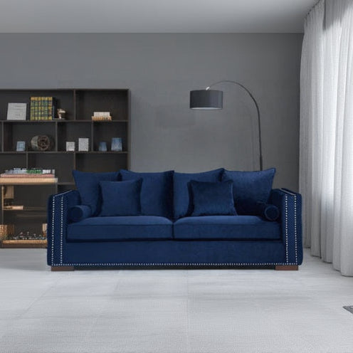 Blue sofa in a room with a bookshelf and lamp.