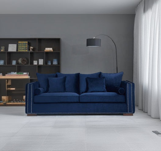 Blue sofa in a room with a bookshelf and lamp.