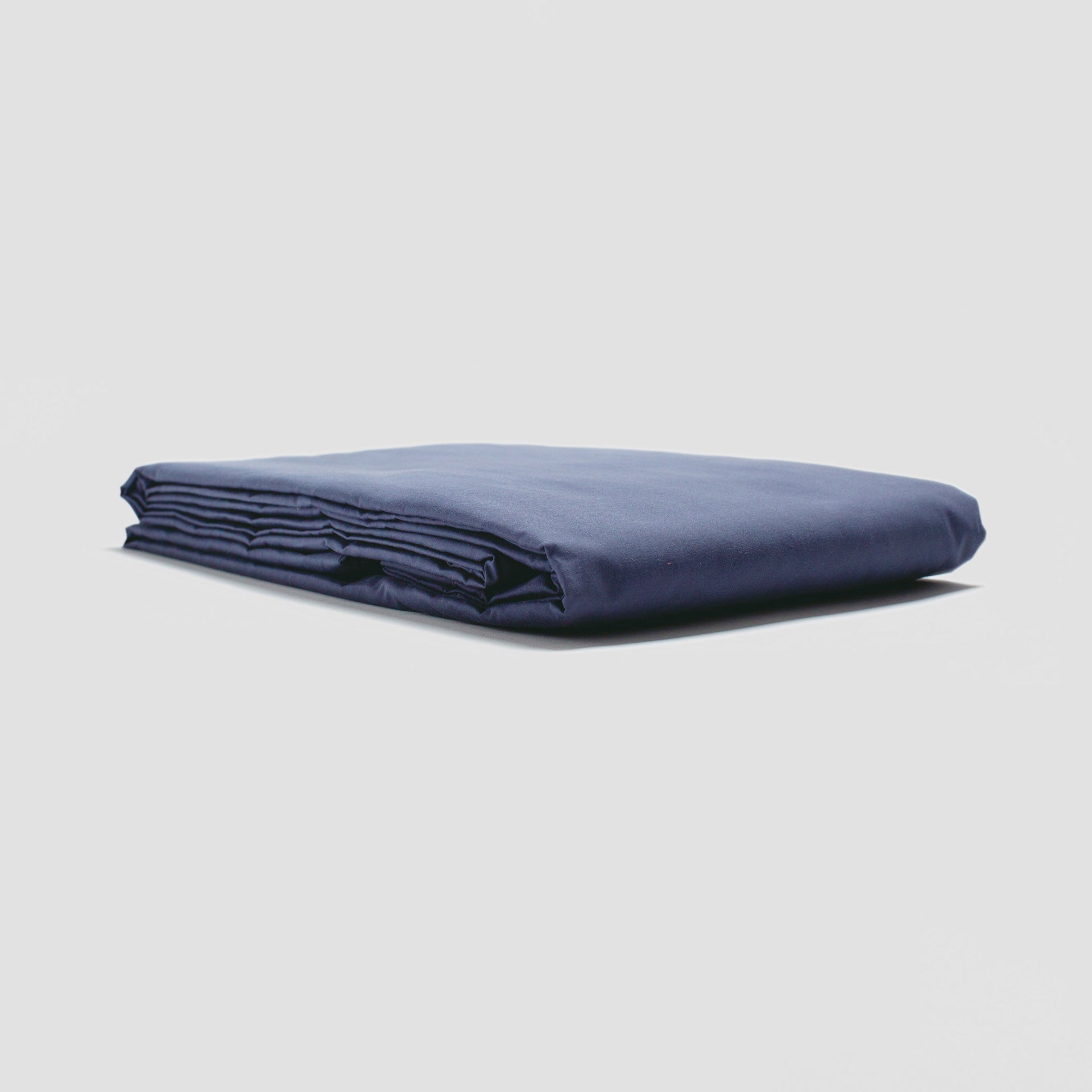 Folded navy blue fabric on a light gray background