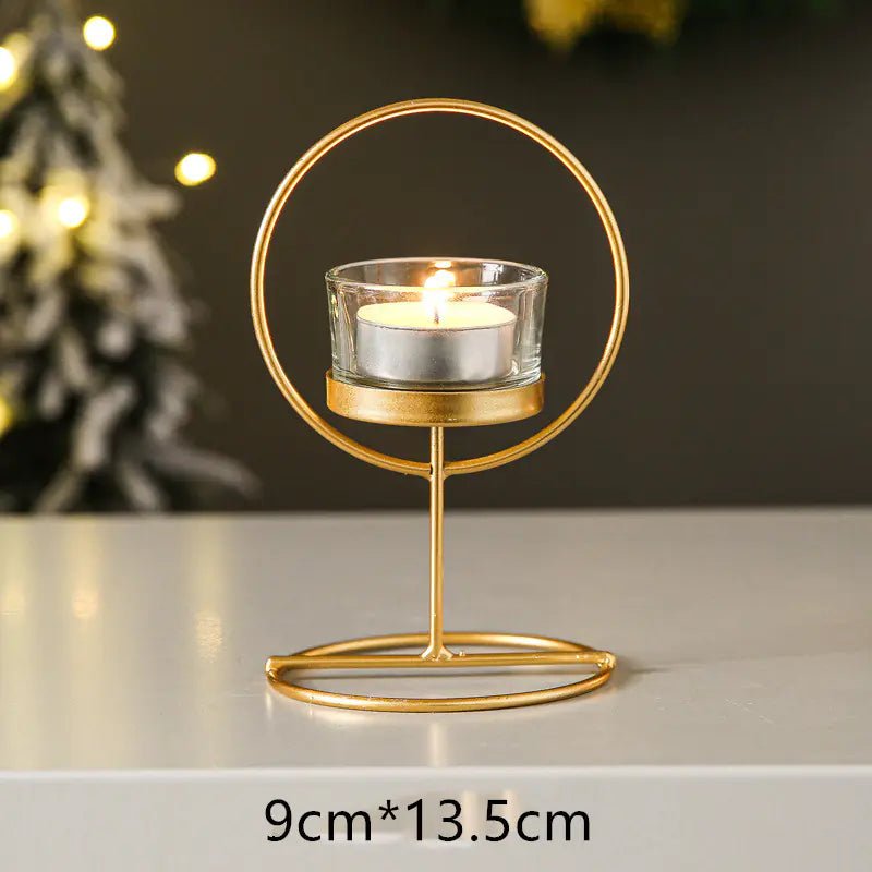 Gold candle holder with a lit candle on a neutral background