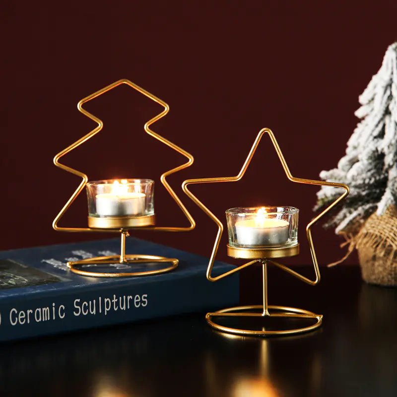 Gold wire tree and star candle holders with lit candles on a dark surface.