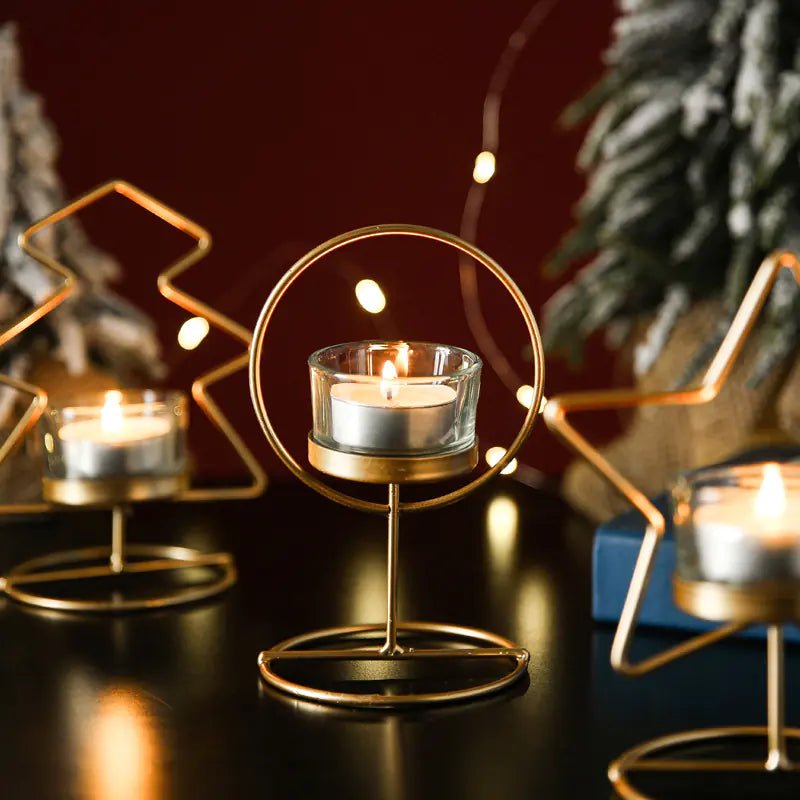 Decorative gold candle holders with lit candles on a dark surface.