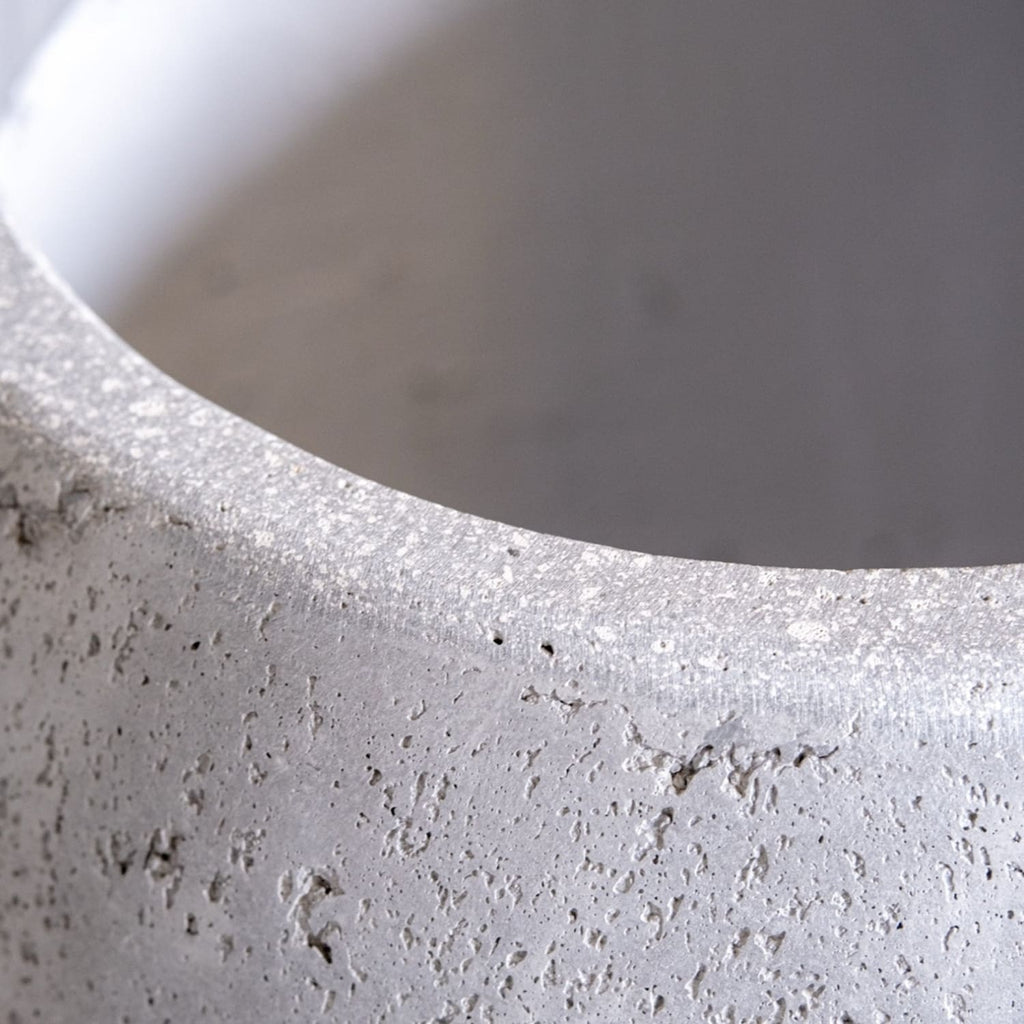 Close-up of a textured concrete pot with a blurred background