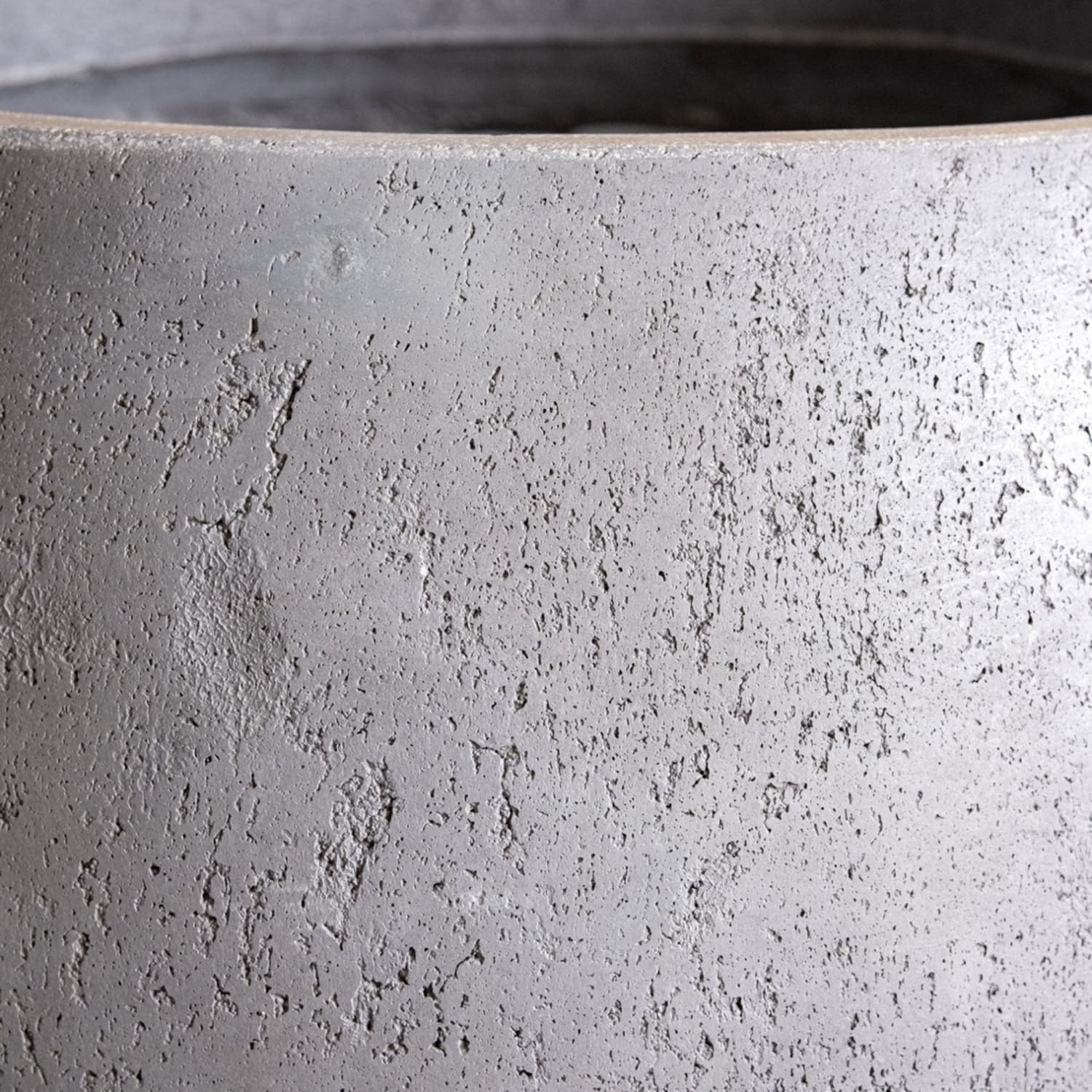 Close-up of a textured gray concrete planter