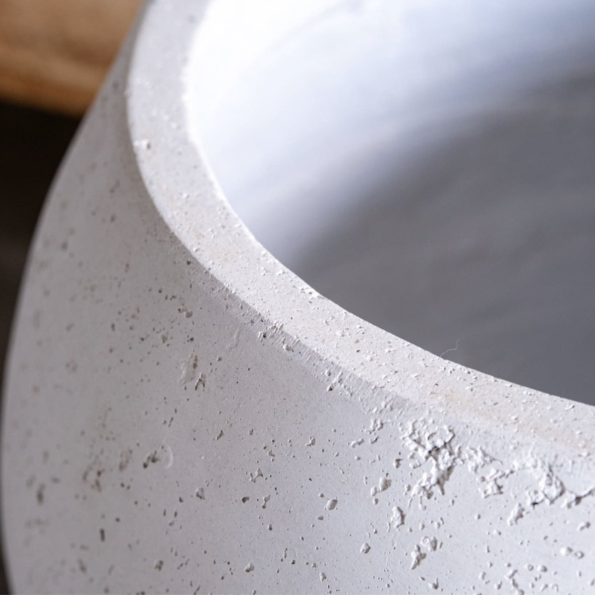 Close-up of a textured concrete surface with a smooth white edge.