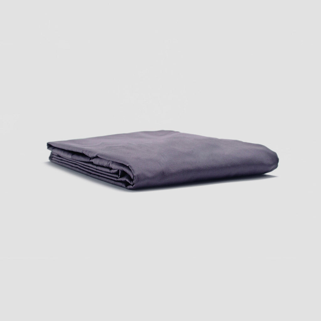Folded purple blanket on a light gray background