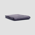 Folded purple blanket on a light gray background