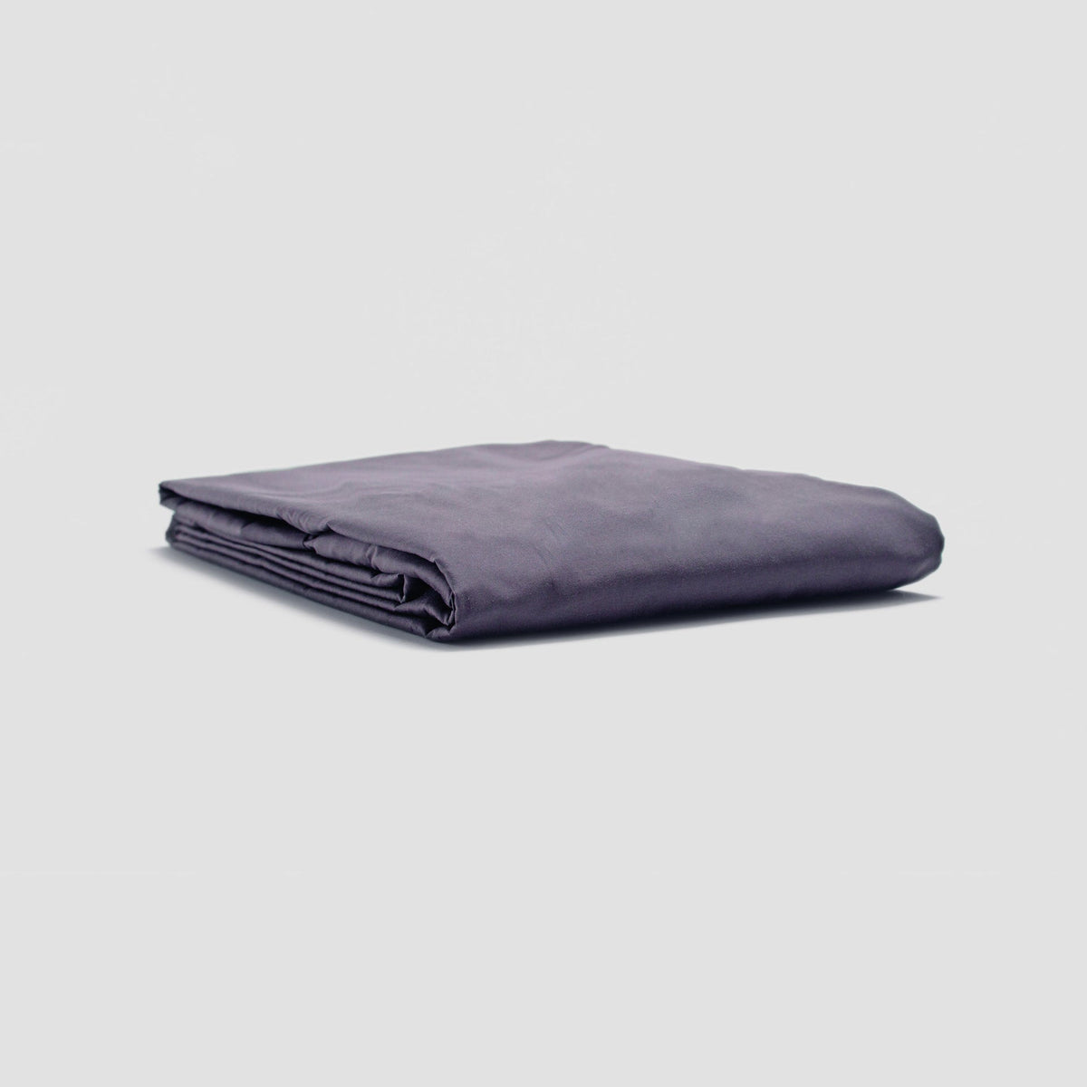 Folded purple blanket on a light gray background