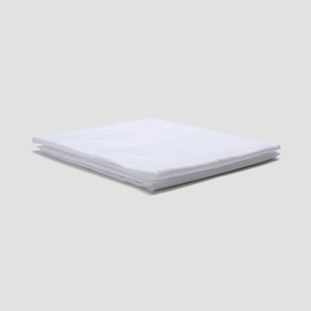 Stack of white folded towels on a light gray background