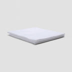 Stack of white folded towels on a light gray background