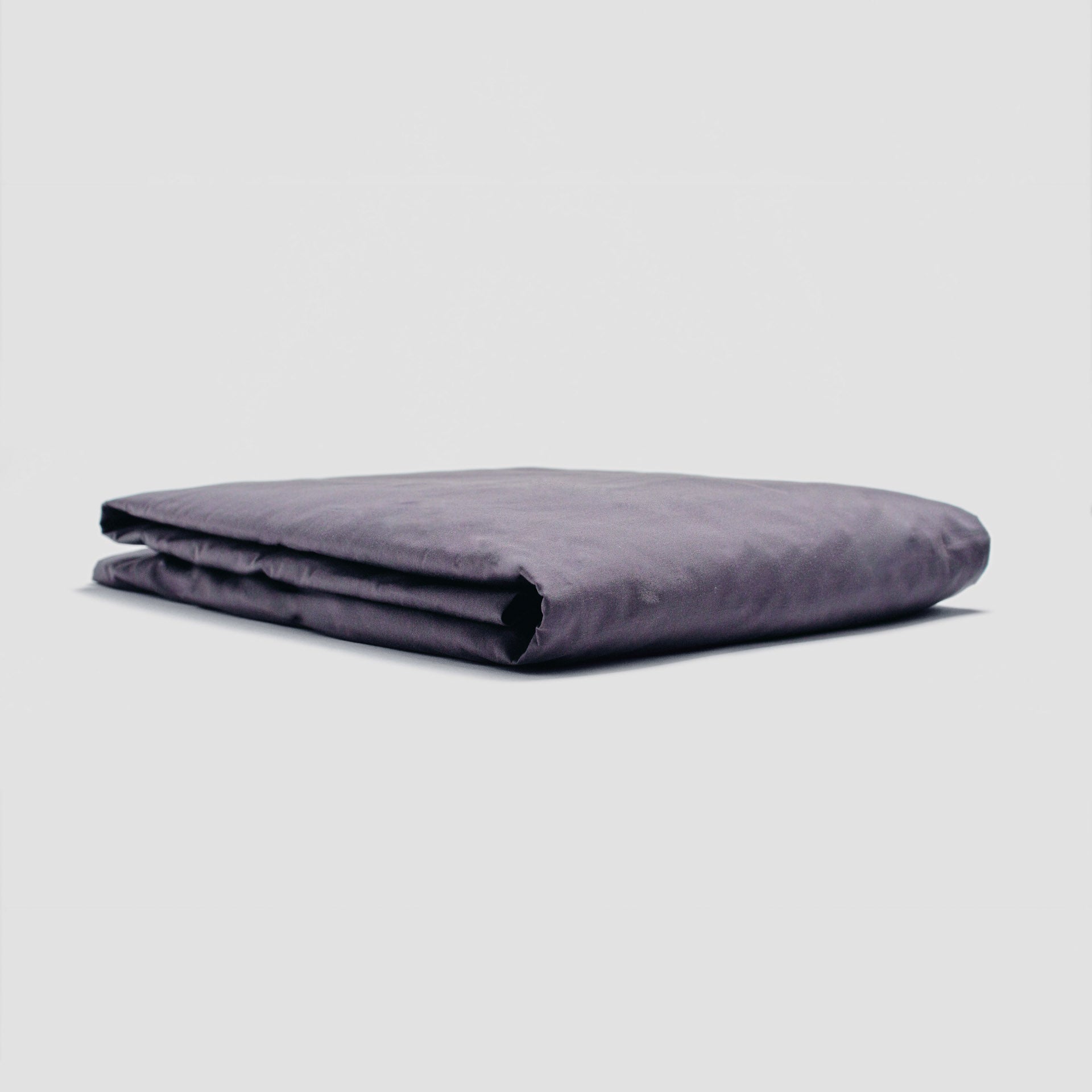 Folded purple blanket on a light gray background