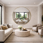 Modern living room with beige sofa, round mirror, and decorative items.