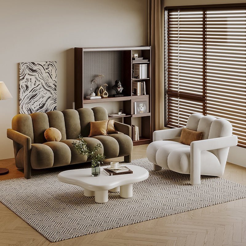 Modern living room with a brown sofa, white armchair, and coffee table.