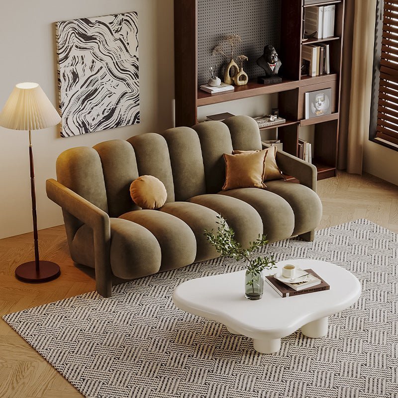 Modern living room with a beige sofa, white coffee table, and decorative items.