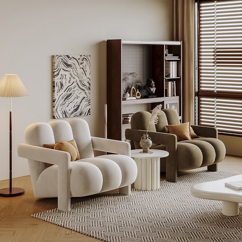 Modern living room with two armchairs, a side table, and a bookshelf.