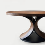 Modern round table with wooden top and black base on a white background