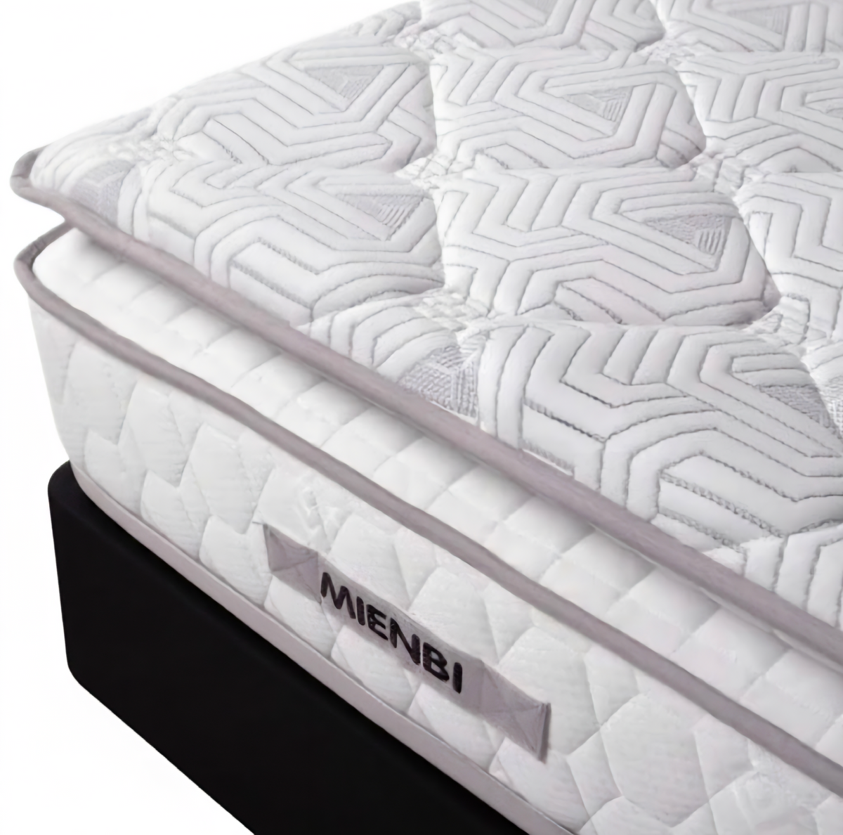 A close-up studio shot of a mattress corner showing a white quilted mattress topper and side panel with the brand name MIENBI, resting on a black mattress base against a white background.