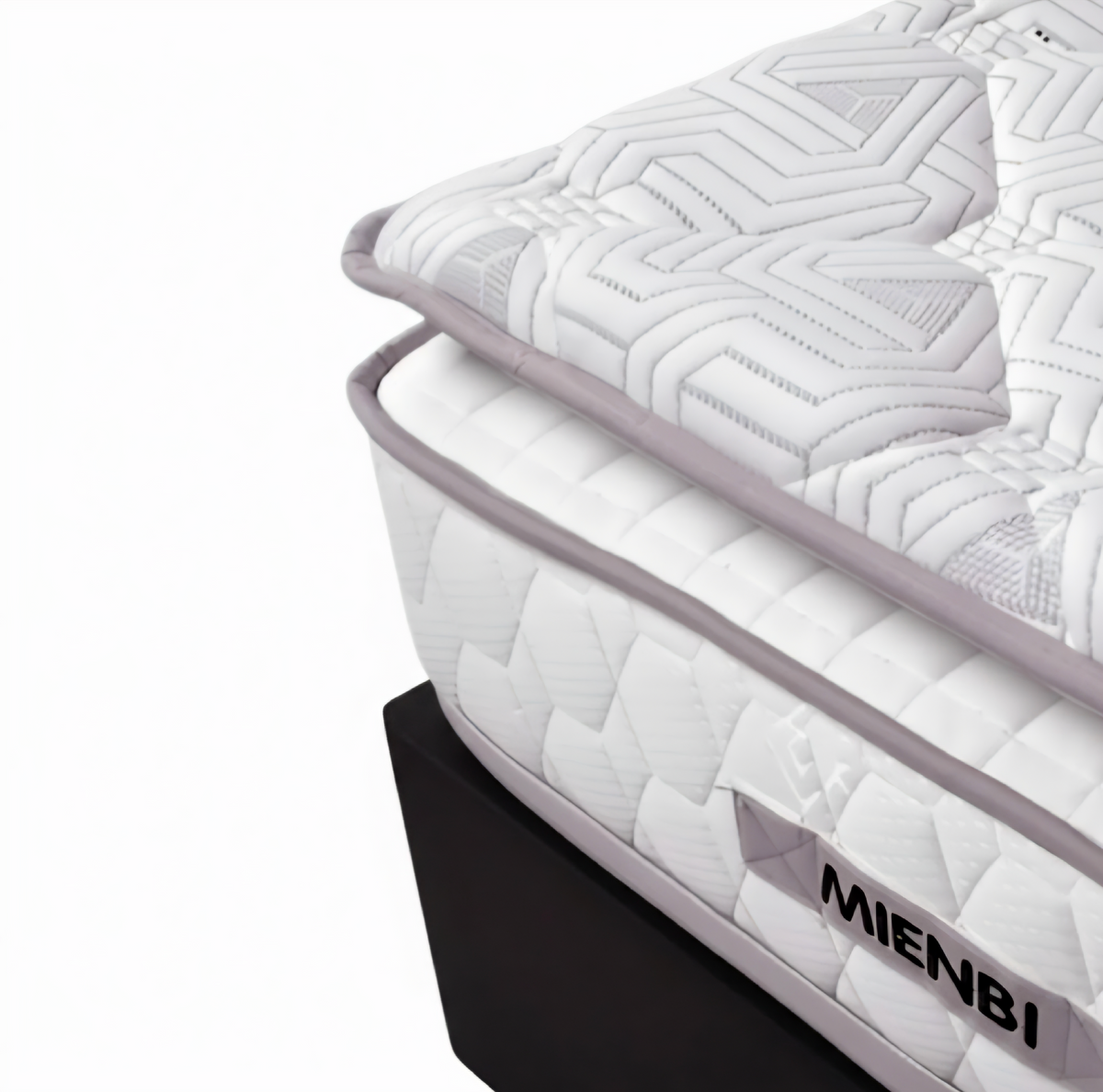 Close-up of a white quilted mattress with geometric stitching, a light gray piping border, and a black base. The brand name MIENBI is visible on a gray label on the side.