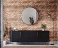 Black cabinet with gold handles against a brick wallpaper with a round mirror above it.