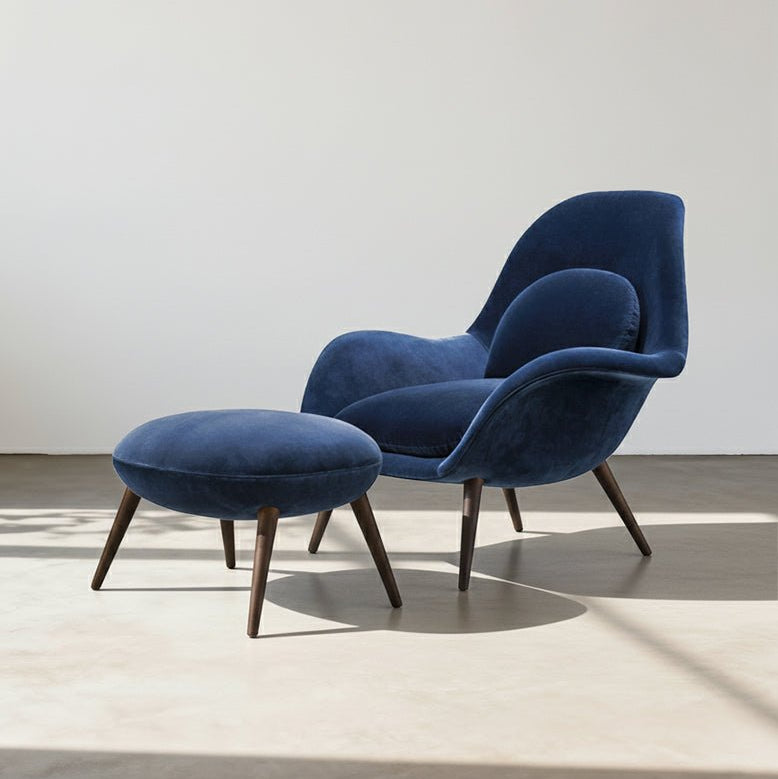Blue armchair with matching ottoman on a light floor and white wall background