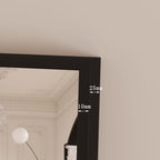 Black framed mirror with measurements on a beige wall