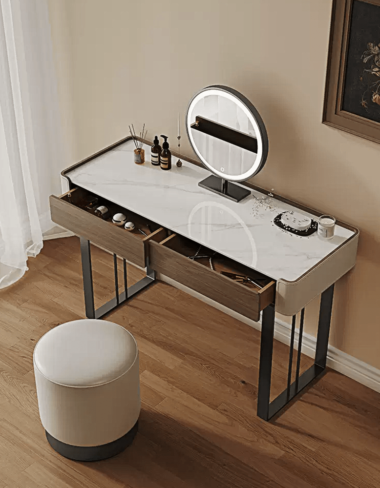 Dressing table with a round mirror and stool on a wooden floor.
