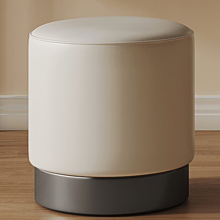 Round beige ottoman with a dark base on a wooden floor.