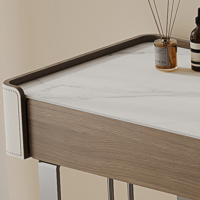 Wooden desk with marble top and decorative items on a neutral background