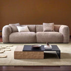 Beige sofa in a living room with a coffee table and decorative items.