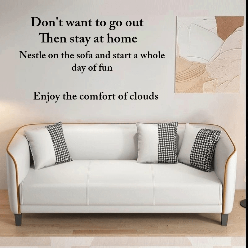 White sofa with patterned cushions in a room with a painting on the wall.