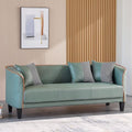 Green sofa with decorative pillows in a room with a wooden wall and framed picture.