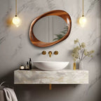 A special-shaped, wall-mounted bathroom mirror with a brown antique-style frame, hanging above a white wash basin, with gold-colored fixtures and a marble countertop.