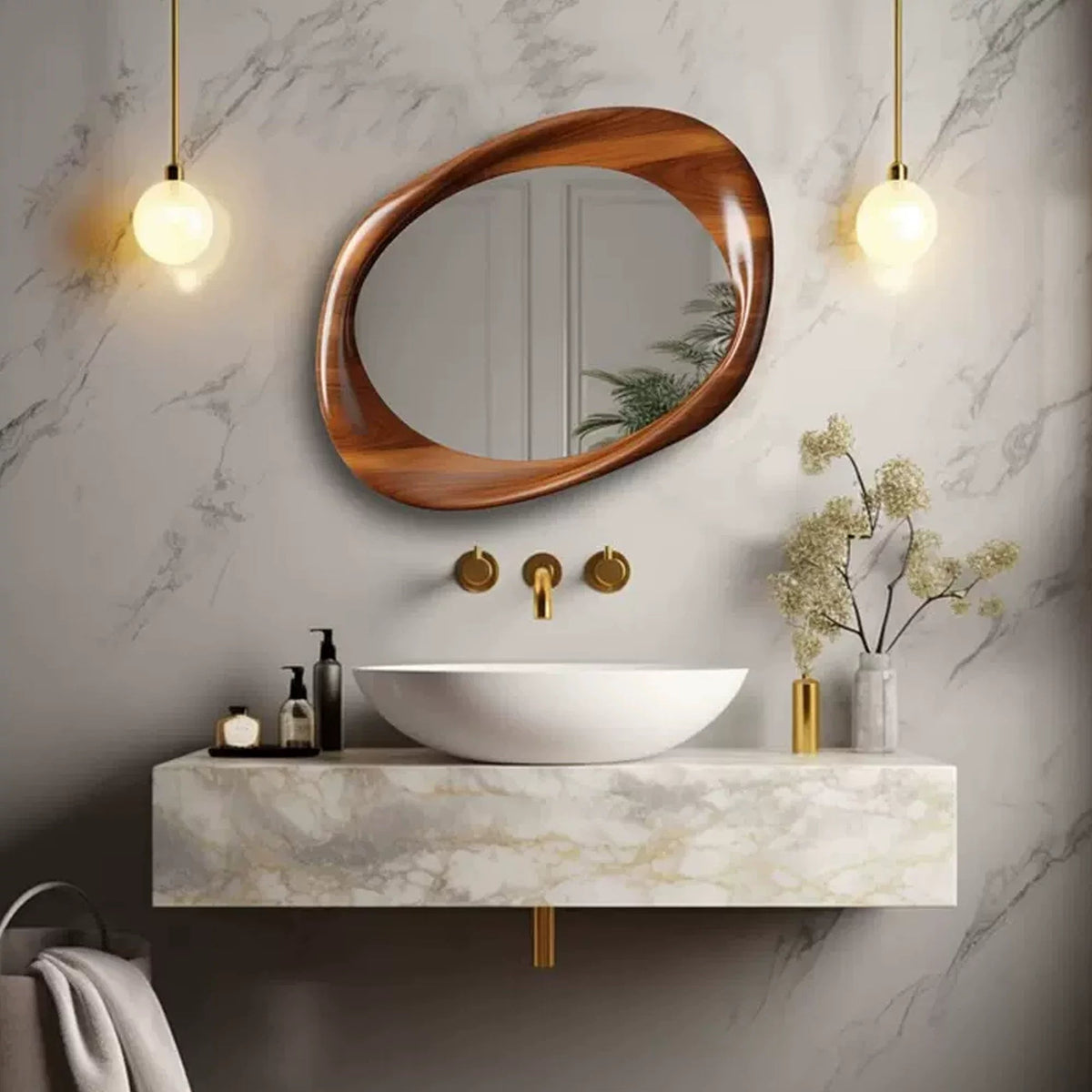 A special-shaped, wall-mounted bathroom mirror with a brown antique-style frame, hanging above a white wash basin, with gold-colored fixtures and a marble countertop.