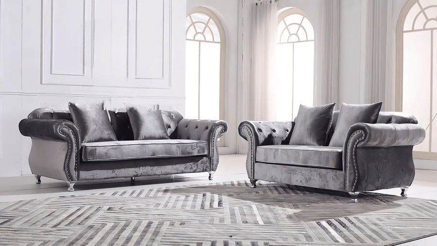 Gray velvet sofa set in a stylish room with large windows.