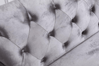 Close-up of a gray tufted headboard with visible wear and tear.