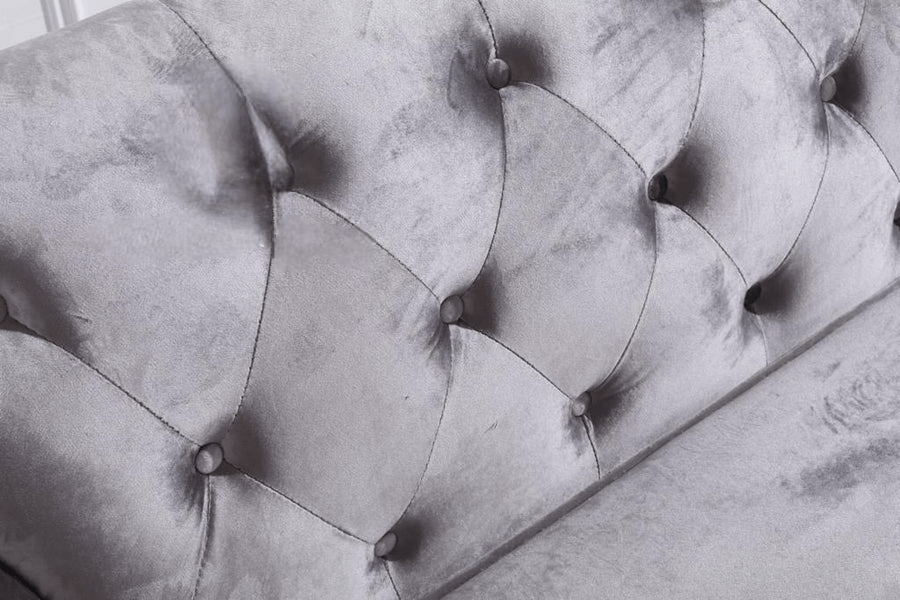 Close-up of a gray tufted headboard with visible wear and tear.