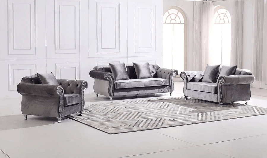 Gray velvet sofa set in a white room with large windows