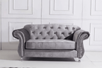 Gray velvet sofa in a room with white paneled walls.