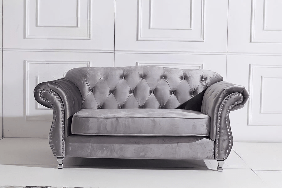 Gray velvet sofa in a room with white paneled walls.