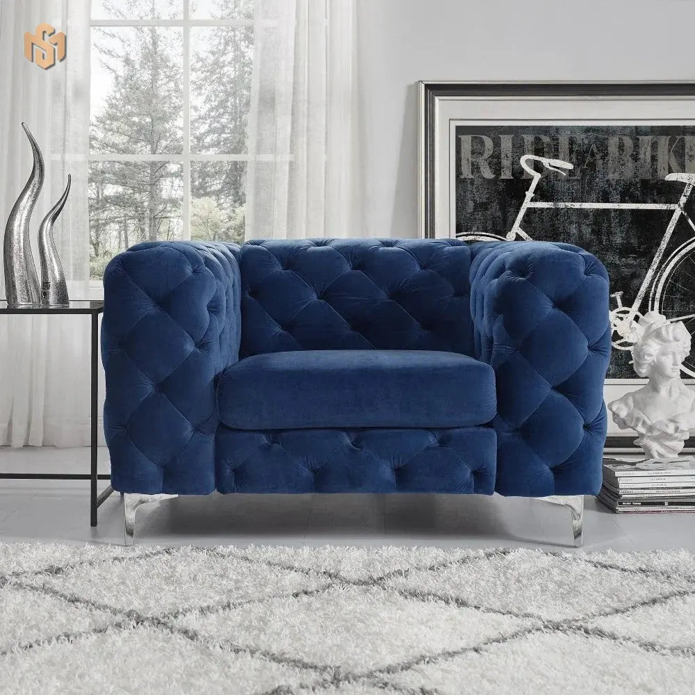 Blue tufted sofa in a room with a bicycle and decorative items.
