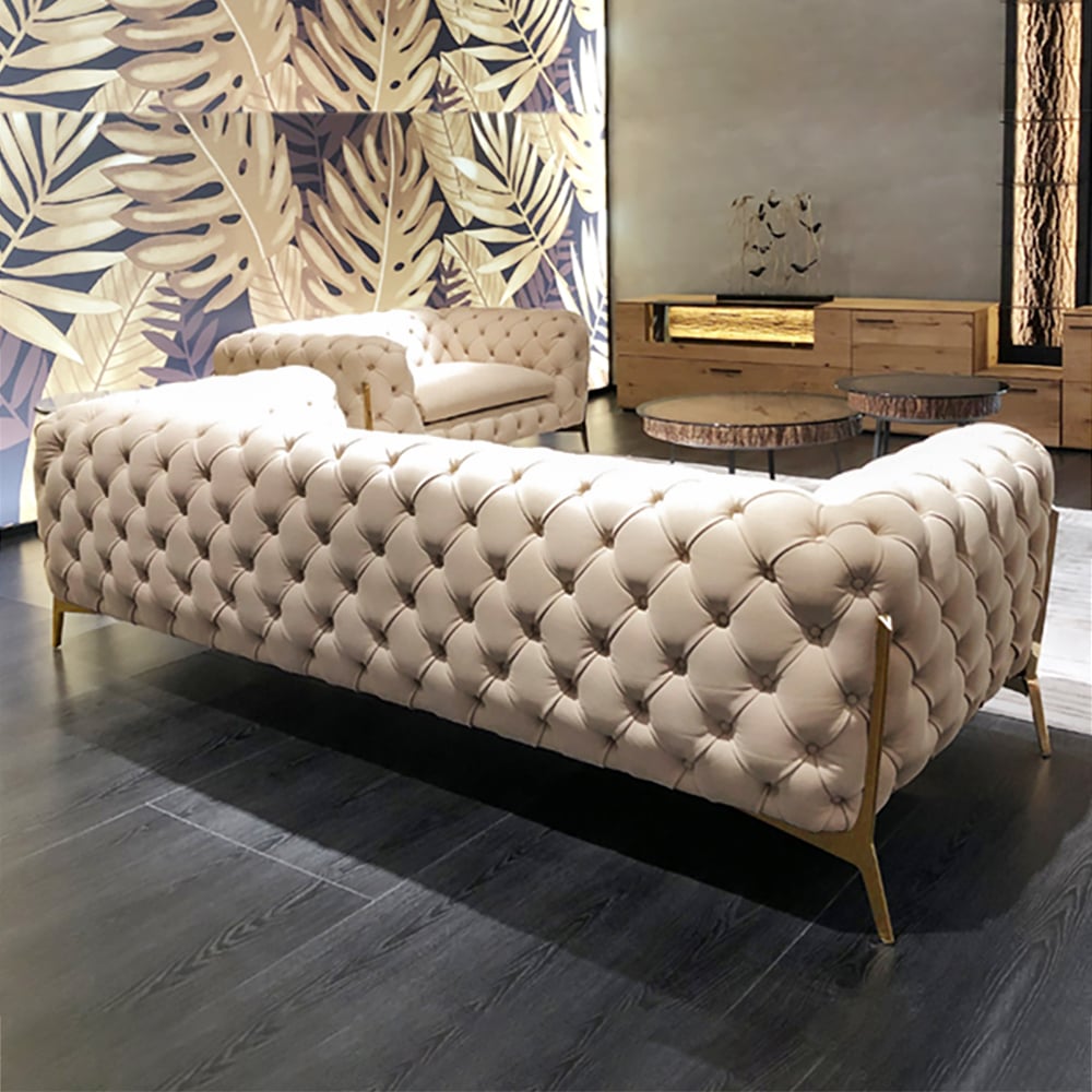 Beige tufted sofa in a stylish room with decorative wall and furniture.