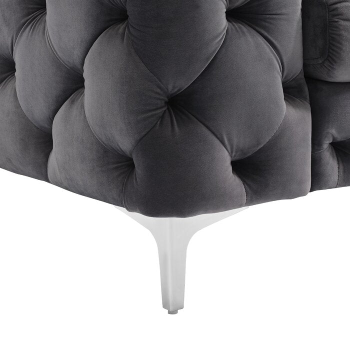 Gray tufted headboard with white legs on a white background