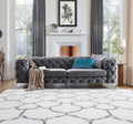 Gray tufted sofa with a blue pillow in a living room setting.