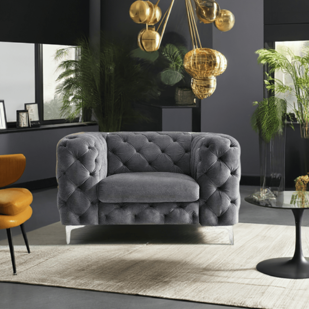 Gray tufted sofa in a modern living room with gold chandelier and plants.