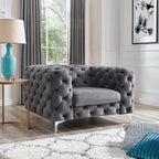 Gray tufted sofa in a living room with a lamp and decorative pillows.
