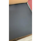 Roll of dark gray paper with a textured edge on a white background