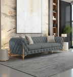 Gray tufted sofa in a living room setting with a large abstract painting on the wall.