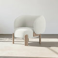 Modern white armchair with wooden legs on a neutral background